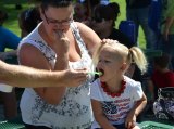 Three-year-old Delilah Clyde gets a bite from Kristine Bowling.